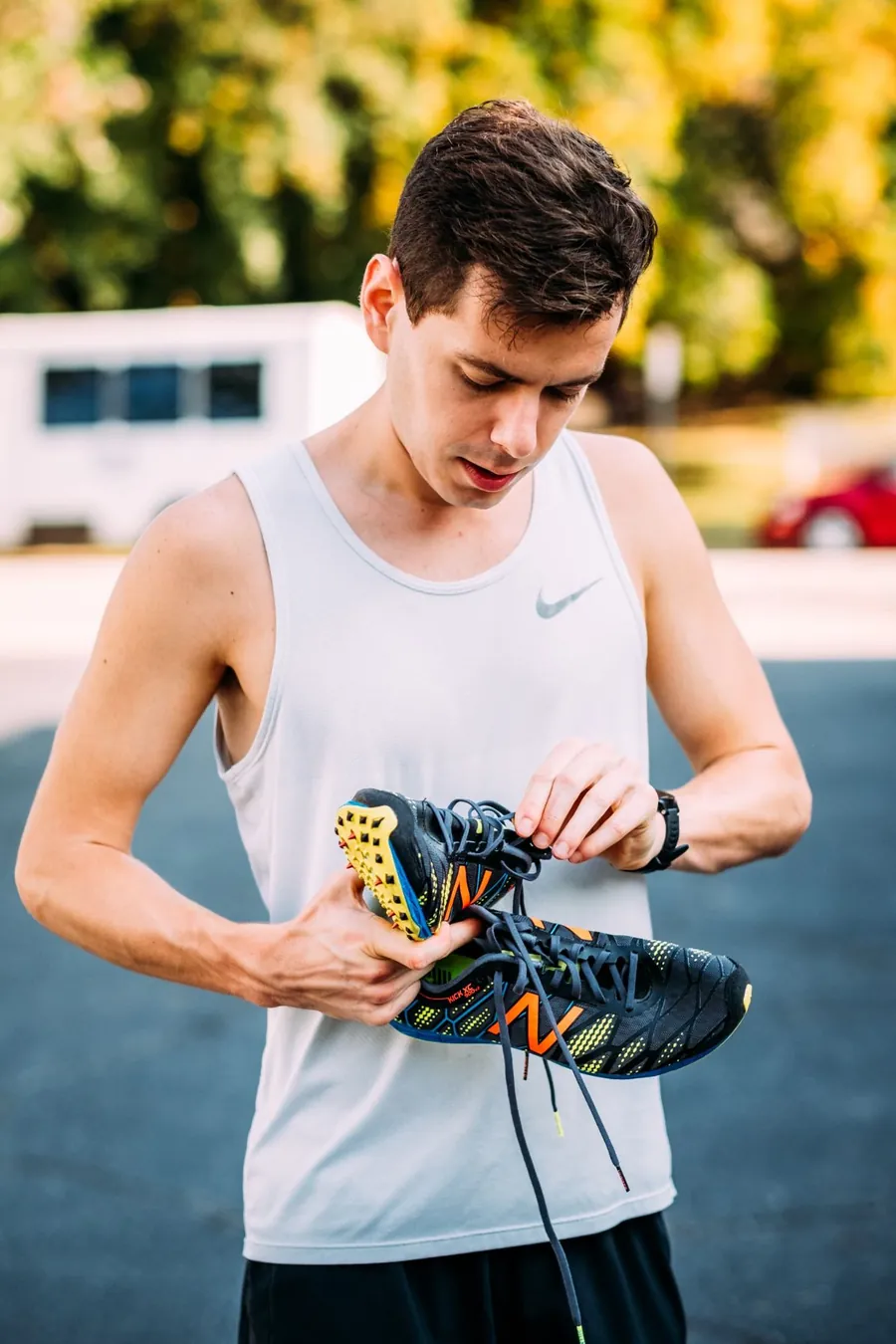 Chris holding a pair of cross-country racing spikes before a race
