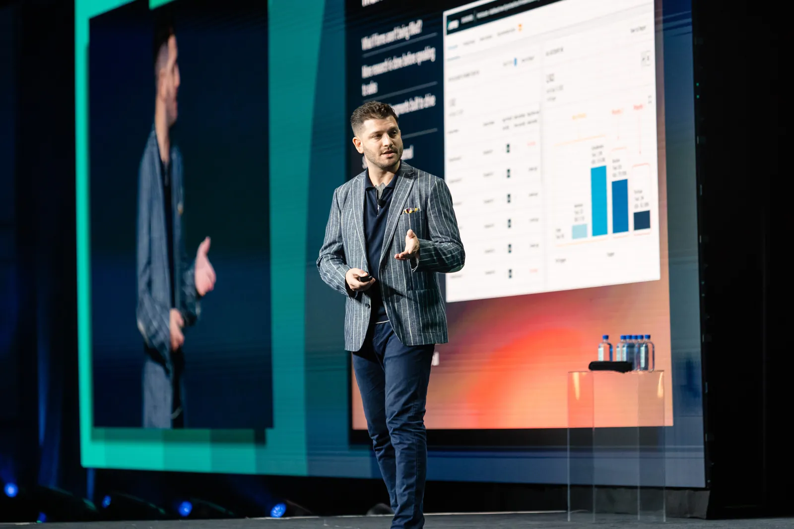 Presenter on stage beside a slide of the 6sense dashboard